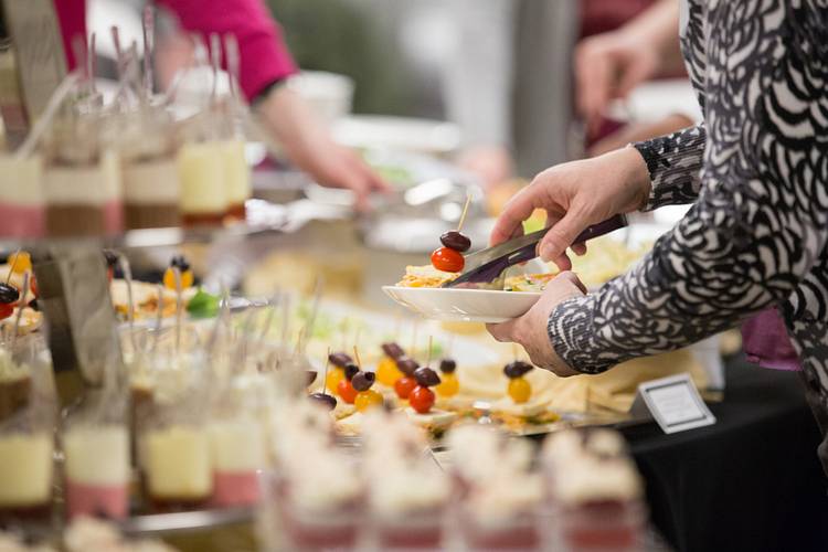 Person grabbing food from a catering spread